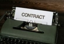 a close up of a typewriter with a sign that reads contact